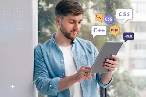 Young web developer learning to code on tablet with floating icons of popular programming languages and technologies: HTML, CSS, JavaScript, PHP, C++, and search symbol